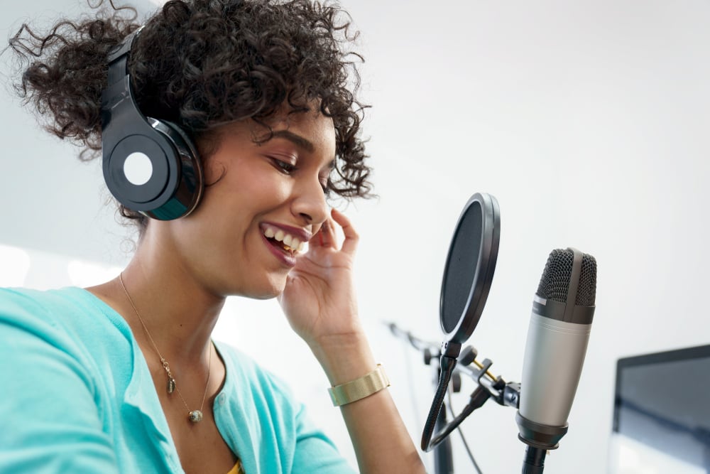 Woman in front of microphone recording podcast